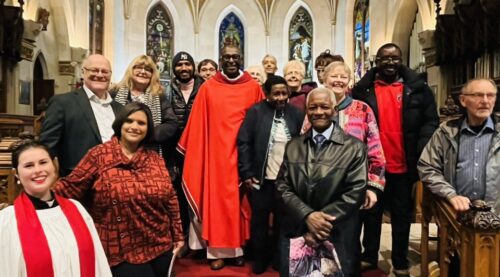 Photo taken on the steps of St Paul's cathedral, London, Ontario. Reverend Gerard is vested in red and surrounded by family and friends