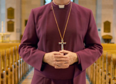 Photo of Bishop Todd Townsend in a cathedral nave wearing purple cassock