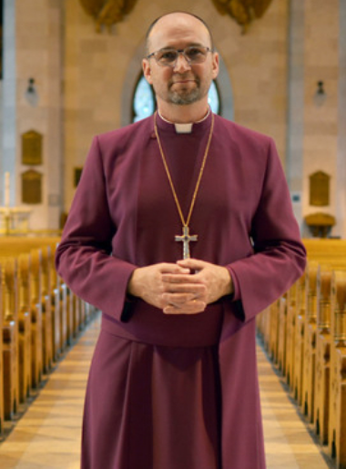 Photo of Bishop Todd Townsend in a cathedral nave wearing purple cassock